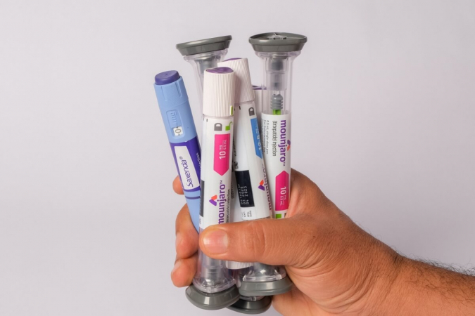 Cinco canetas injetoras de medicamentos para emagrecimento, lado a lado, cada uma sobre um fundo de cor diferente